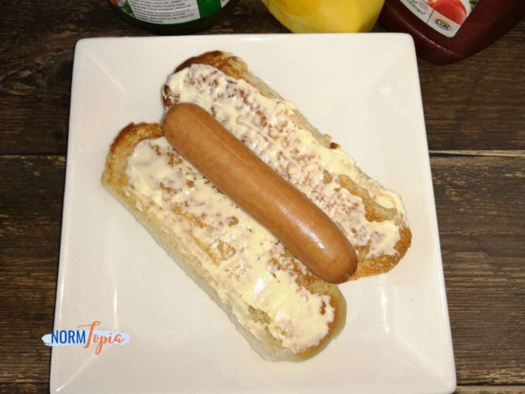 Spread the mayo on a bun and place a hot dog.